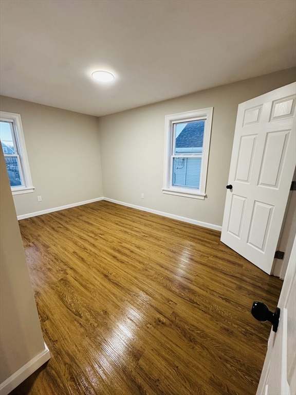 49 Lawrence Street, Unit 2 Salem, MA 01970 - Photo 3 of 13 a view of an empty room with wooden floor and a window