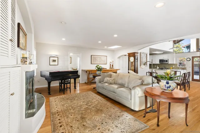 a living room with furniture a dining table and a refrigerator