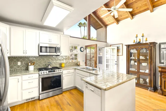 a kitchen with stainless steel appliances granite countertop a stove and a white cabinets