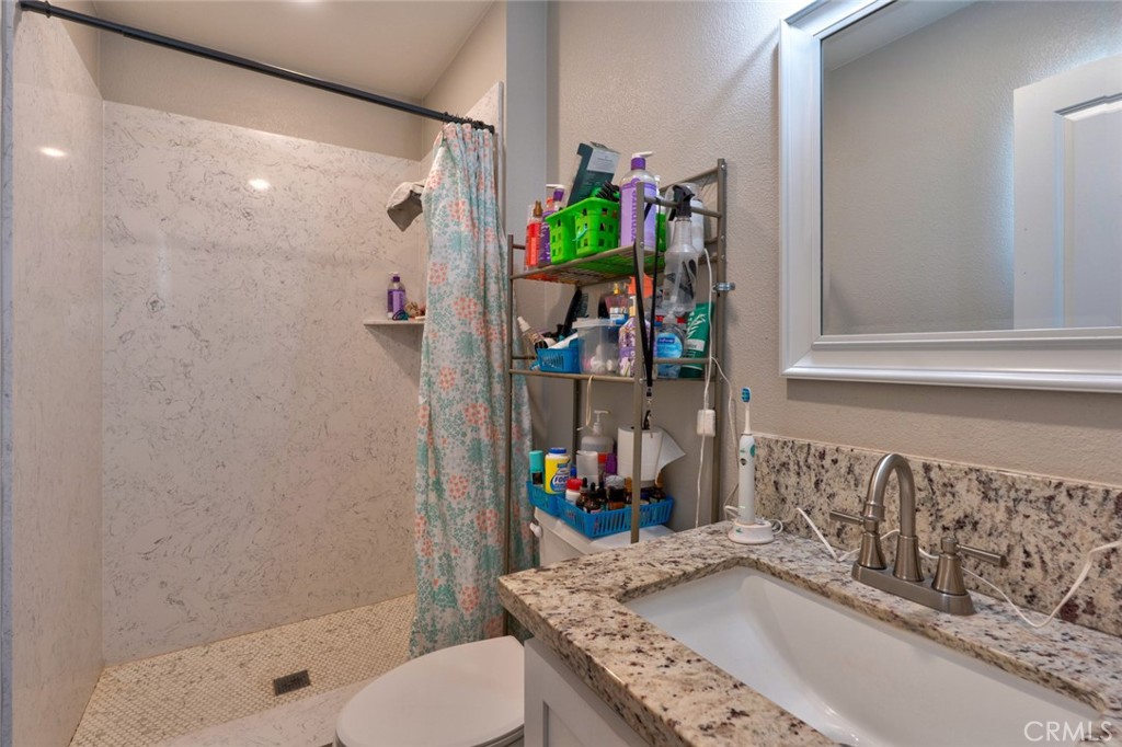 1840 Cheyenne Drive Merced, CA 95348 - Photo 49 of 90 a bathroom with a granite countertop sink a toilet and shower