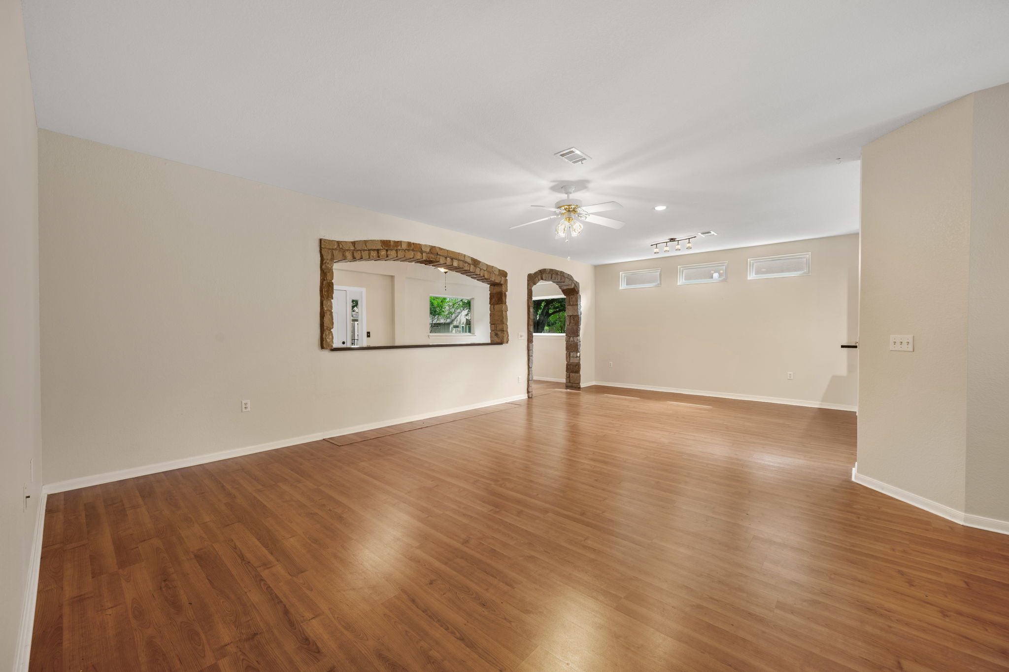 118 Bass Street Georgetown, TX 78633 - Photo 10 of 40 Natural light illuminates rich hardwood-style flooring, complementing unique stone archways and thoughtful built-in details.