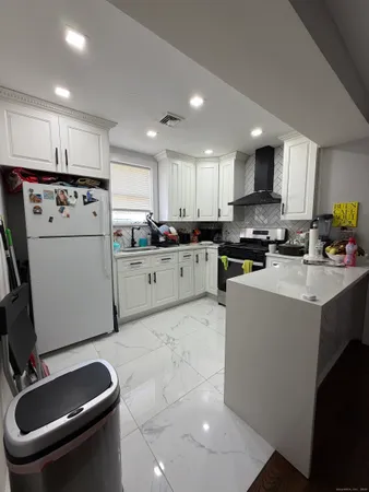 a kitchen with a sink a stove a refrigerator cabinets and a counter top space