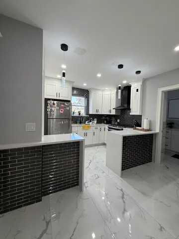 a kitchen with stainless steel appliances granite countertop a refrigerator and a stove top oven