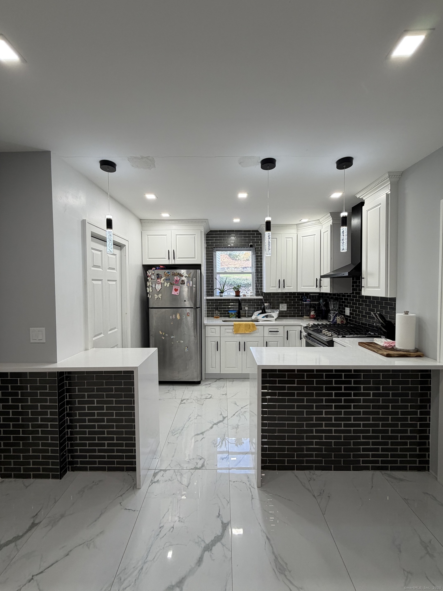 2964 State Street, Unit 1 Hamden, CT 06517 - Photo 5 of 18 a large kitchen with stainless steel appliances a large counter top a stove and a refrigerator