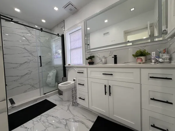 a bathroom with a granite countertop sink a toilet and shower