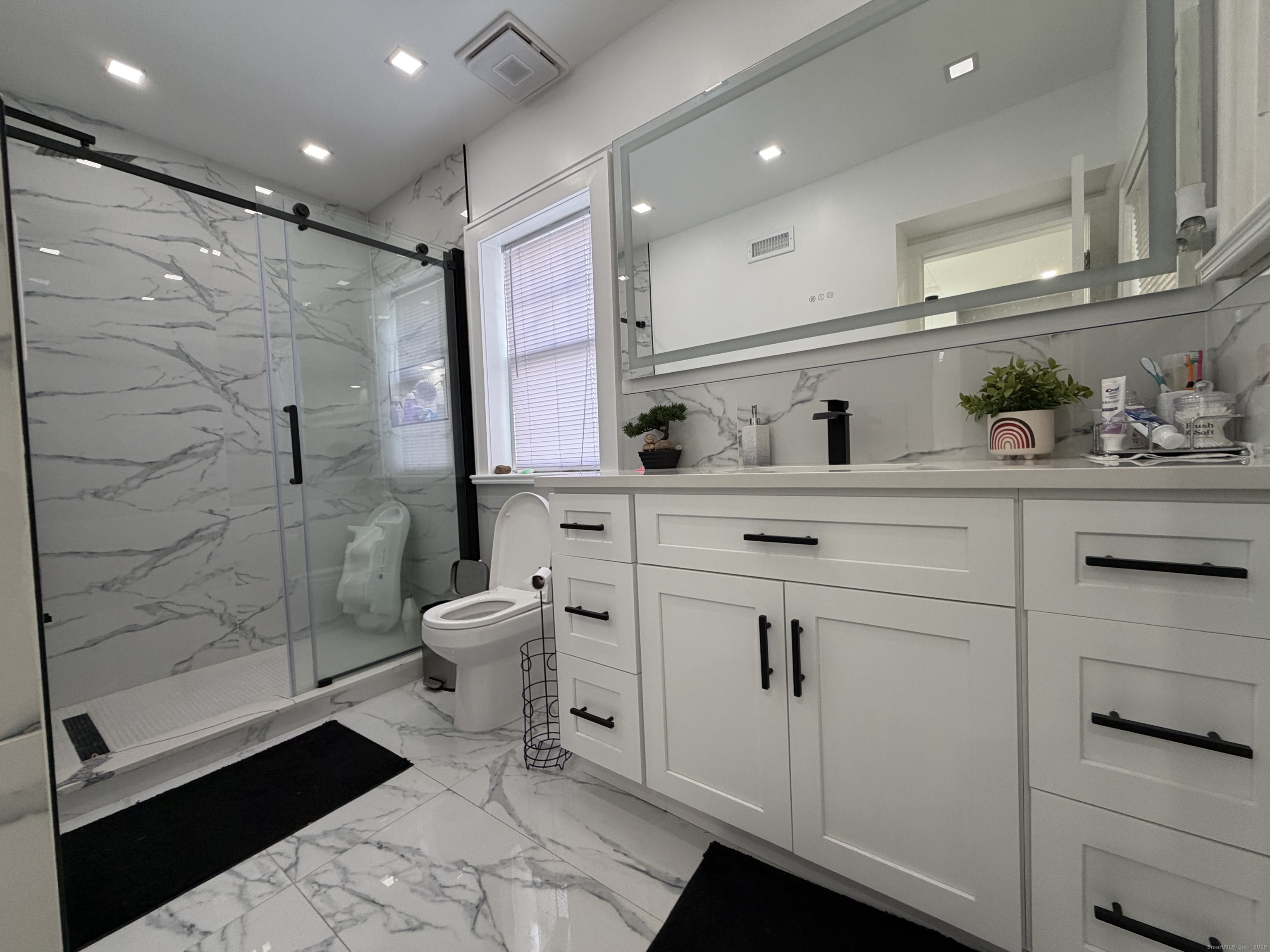 2964 State Street, Unit 1 Hamden, CT 06517 - Photo 8 of 18 a bathroom with a granite countertop sink a toilet and shower