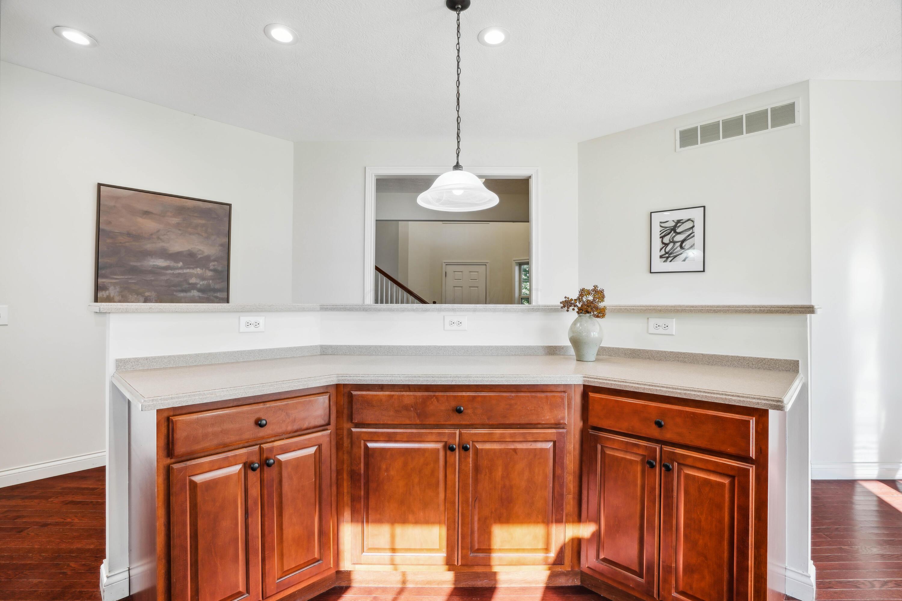 10403 Liberty Road Powell, OH 43065 - Photo 29 of 76 Open Kitchen with countertop seating, NEW SS appliances, Dining Area, Cherry cabinets with custom vent hood, corian countertops and walk-in pantry plus beautiful hardwood floors!