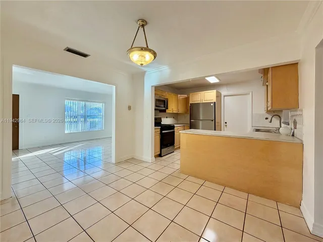 a kitchen with a sink a refrigerator and cabinets
