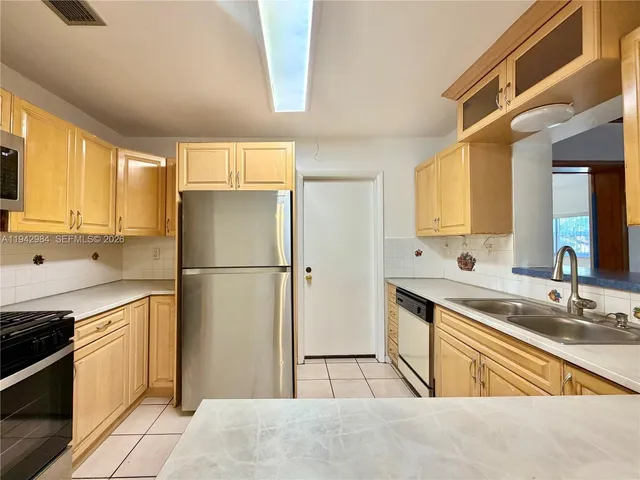 a kitchen with granite countertop a refrigerator stove and microwave