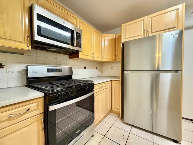 a kitchen with stainless steel appliances a sink stove and cabinets