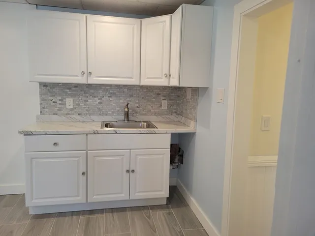 a kitchen with white cabinets and white appliances