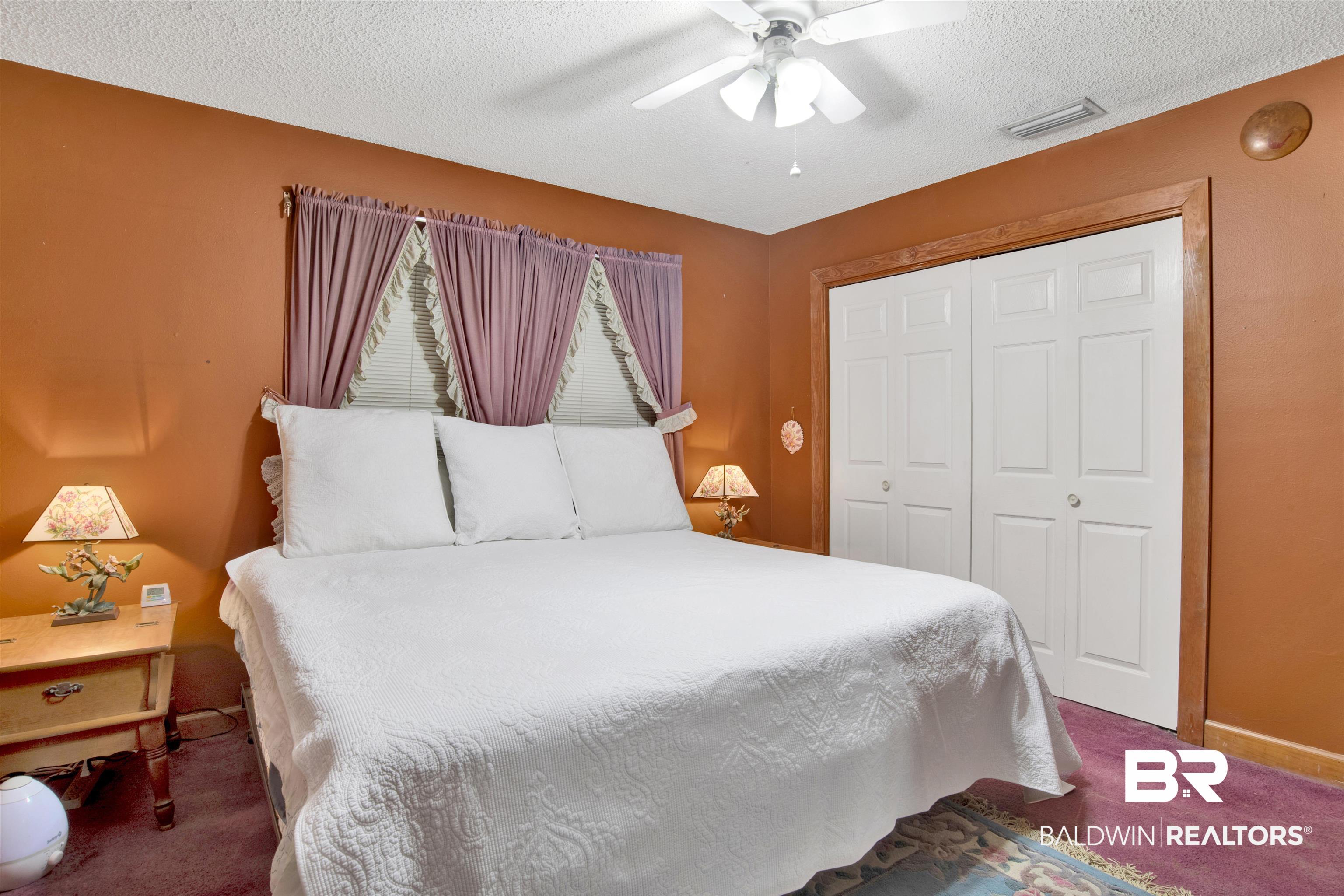 4890 Red Creek Road Semmes, AL 36575 - Photo 25 of 47 Bedroom with a closet, a textured ceiling, dark carpet, and ceiling fan