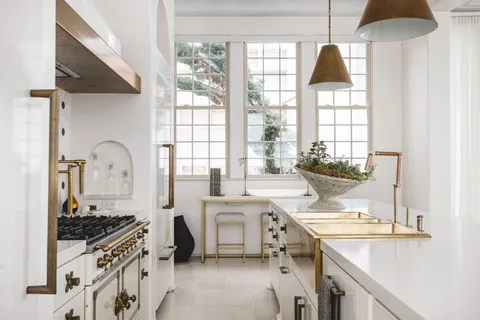 a kitchen with a stove a sink and a window