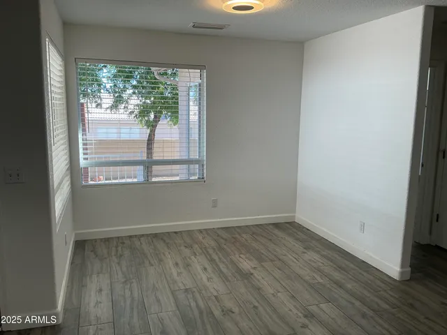 an empty room with wooden floor and window