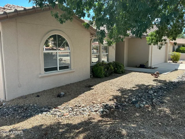 a front view of a house with a tree