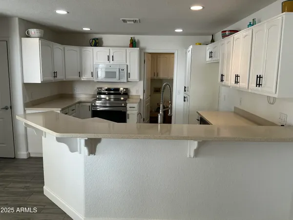 a kitchen with stainless steel appliances a sink a stove and cabinets