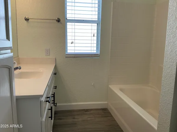 a bathroom with a double vanity sink a mirror and a bathtub