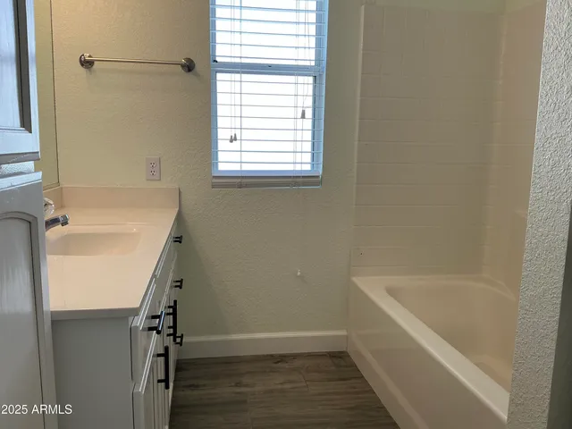 a bathroom with a double vanity sink a mirror and a bathtub