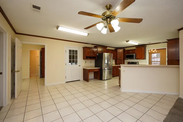 a kitchen with stainless steel appliances kitchen island granite countertop a refrigerator stove and sink