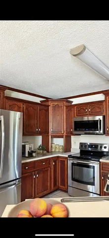 a kitchen with stainless steel appliances granite countertop a refrigerator and a stove top oven