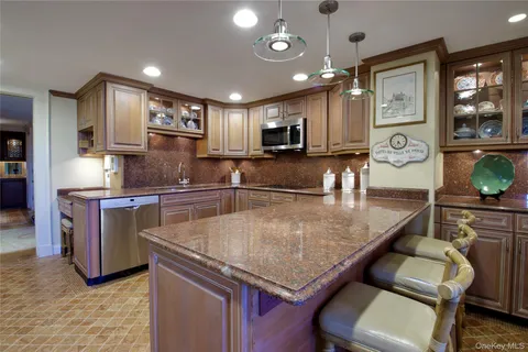 a kitchen with stainless steel appliances granite countertop a sink a stove and a refrigerator