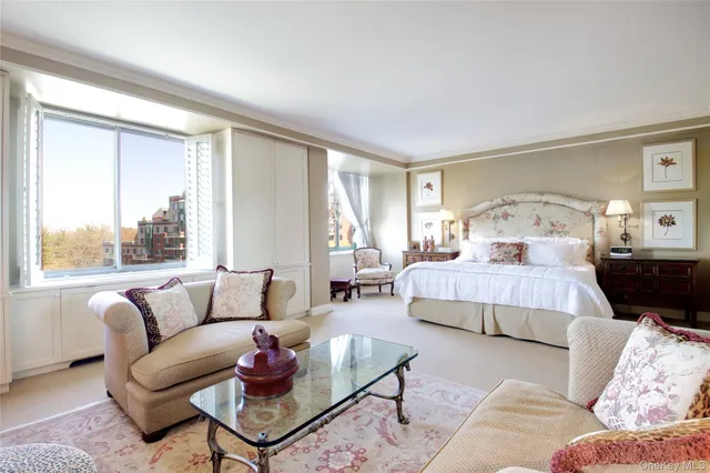 a bedroom with furniture and a large window