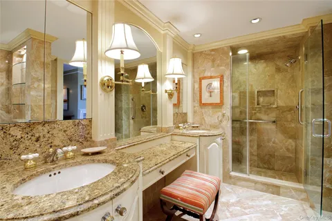 a bathroom with a granite countertop sink mirror and shower