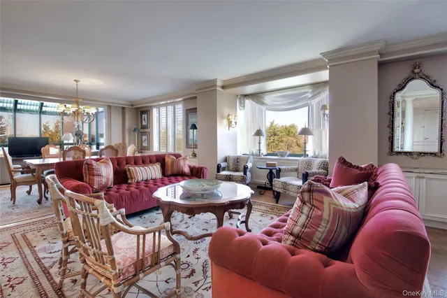 a living room with furniture kitchen view and large windows
