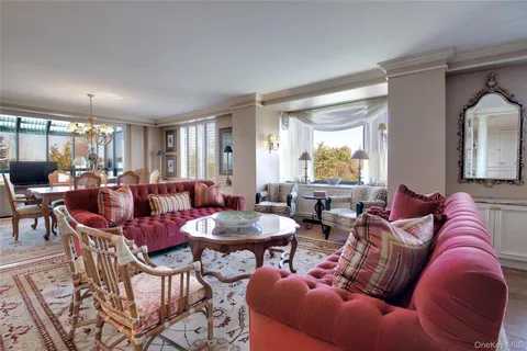 a living room with furniture kitchen view and large windows