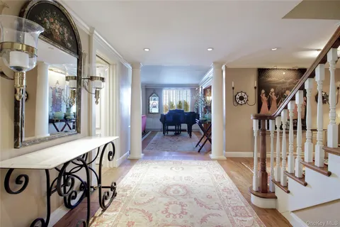 a view of a hallway with furniture and a chandelier