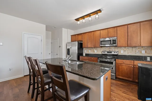 a kitchen with stainless steel appliances granite countertop a stove a sink and a microwave