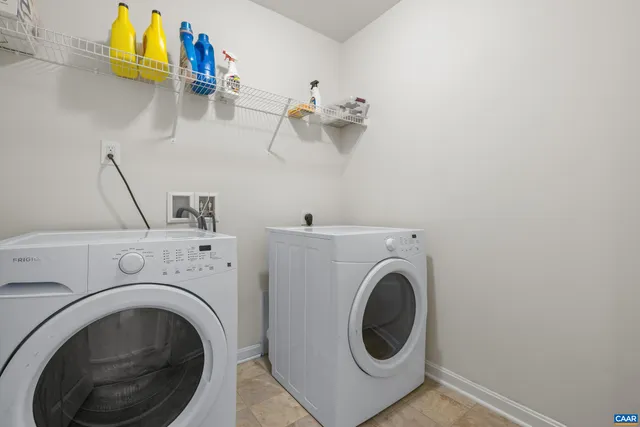 a view of a white house with a yard and a fountain