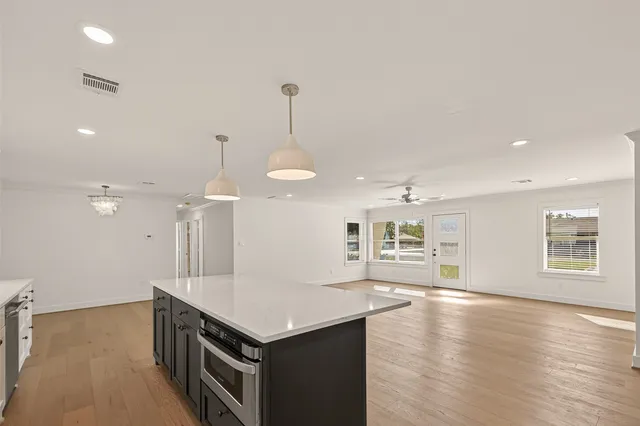 a kitchen with a stove kitchen island and a wooden floor