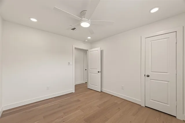 a view of an empty room with a window and a ceiling fan