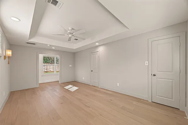 an empty room with a ceiling fan and a window