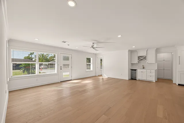 a view of an empty room with a window and wooden floor