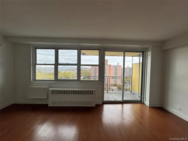 an empty room with wooden floor and balcony