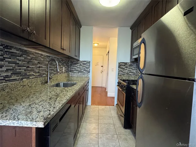 a kitchen with a granite countertop sink stove and refrigerator