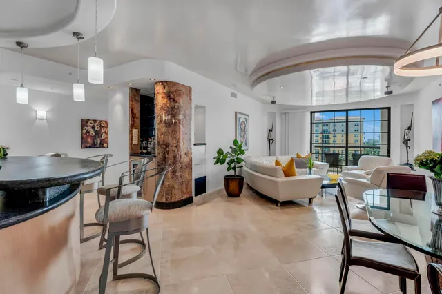 a living room with furniture a chandelier and a large window