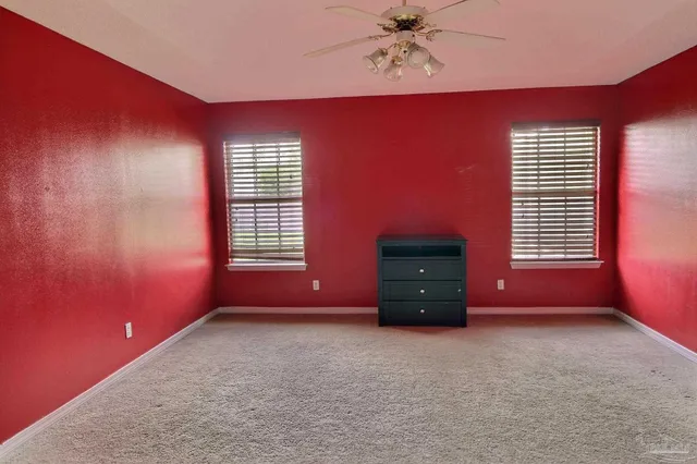 an empty room with a window and a ceiling fan