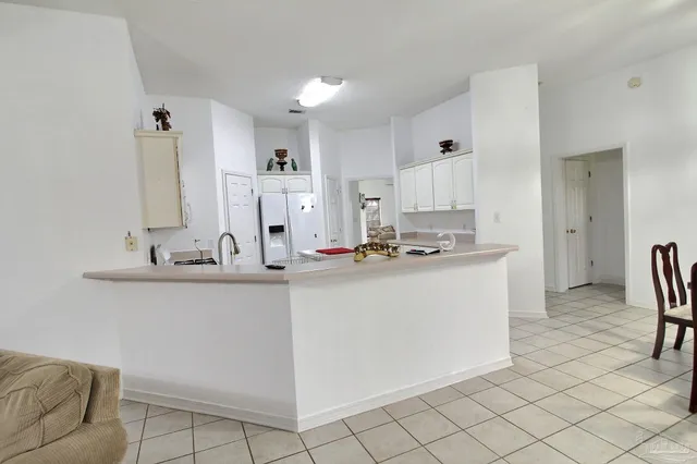 a kitchen with cabinets and chairs