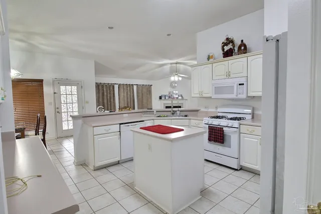 a kitchen with white cabinets and white appliances