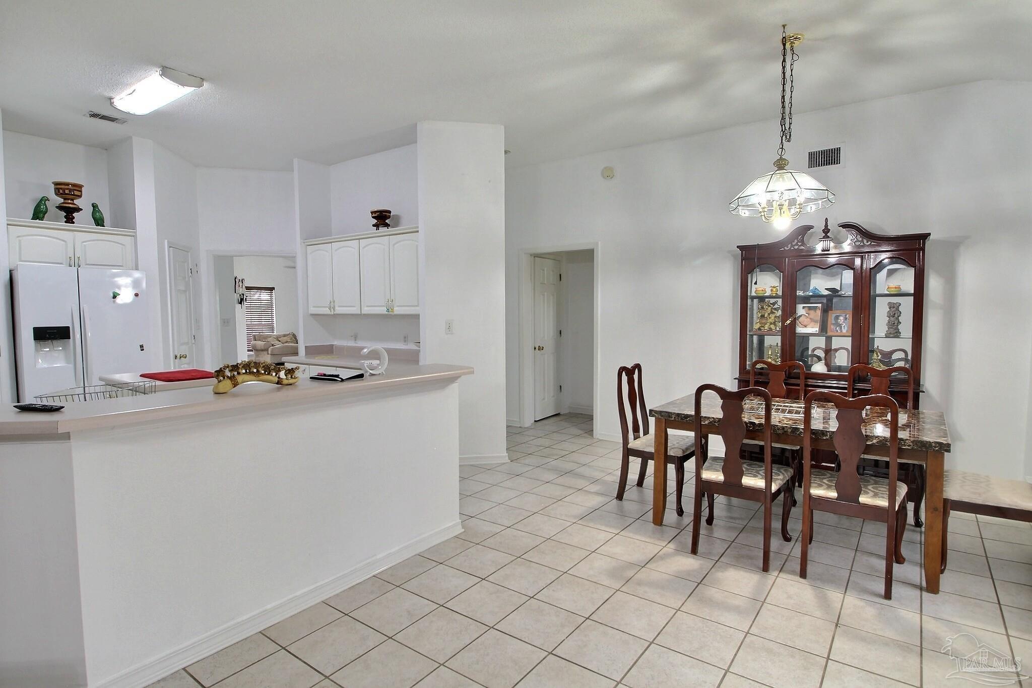 213 Newberry Street Cantonment, FL 32533 - Photo 8 of 23 a kitchen with kitchen island granite countertop a dining table chairs sink and cabinets