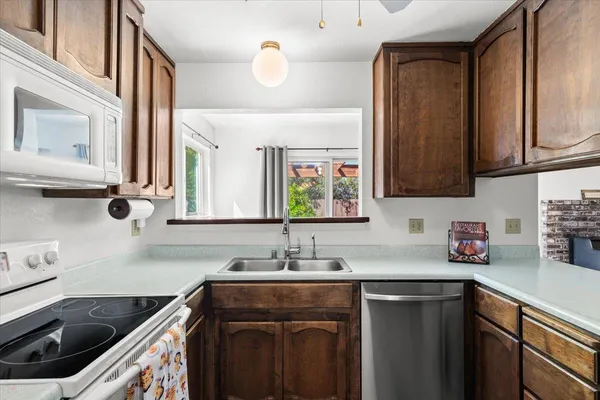 a kitchen with a sink stove top oven and cabinets