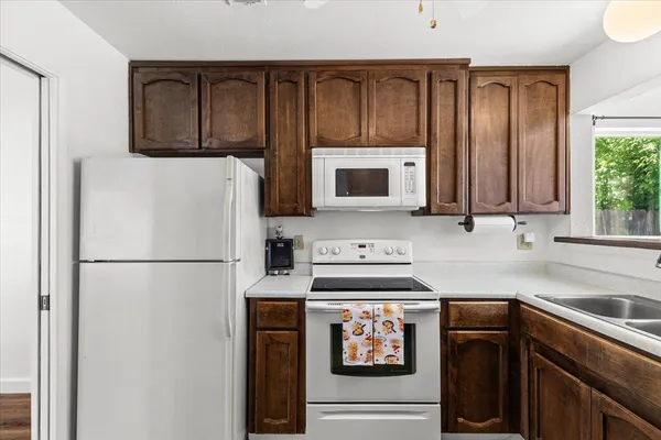 a kitchen with stainless steel appliances granite countertop a refrigerator stove a sink and dishwasher with wooden floor
