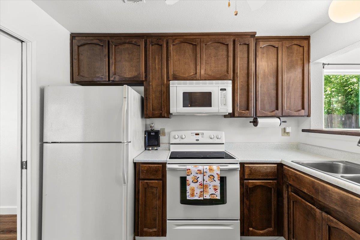 185 East Wyman Road French Camp, CA 95231 - Photo 14 of 44 a kitchen with stainless steel appliances granite countertop a refrigerator stove a sink and dishwasher with wooden floor