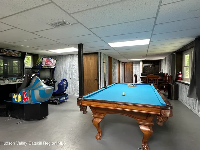a room with pool table gym equipment wooden floor and window