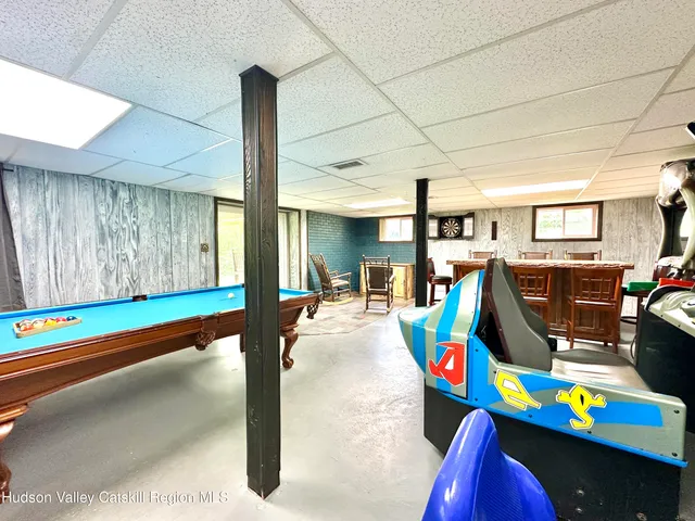 a living room with patio furniture and a baby crib