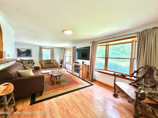 a living room with furniture large window and a wooden floor