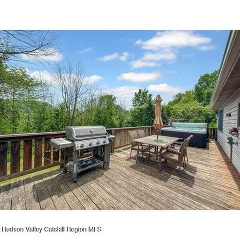 a roof deck with table and chairs a barbeque with wooden fence